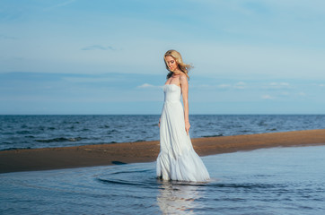 Fototapeta na wymiar Portrait of young blond bride walking among the water