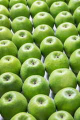 background of many green apples laid out in even rows