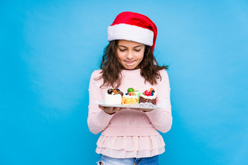 Little girl holding sweets celebrating christmas day