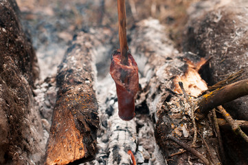 Picnic in the wood: grilled sausages on camp fire