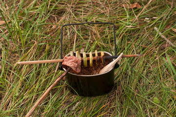 Picnic in the wood: grilled sausages on camp fire