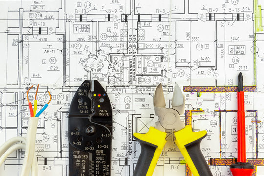Electrican components and tools arranged in flat lay formation on a electrical plan