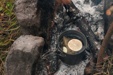 Aromatic and hot herbal tea  on campfire	