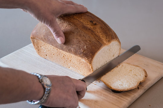 Woman Cutting A Loaf Of White Bread