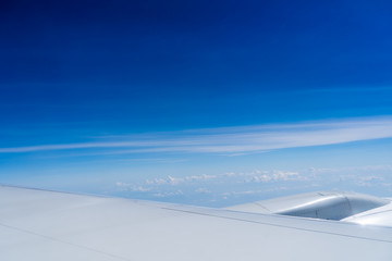 Airplane wing with sky and clouds background