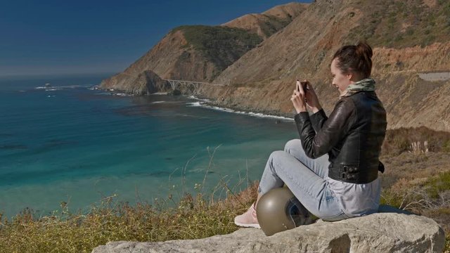 Woman filming Creek Bridge view in California, USA.