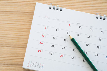 calendar page with pencil on wood table background