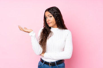 Young woman over isolated pink background unhappy for not understand something