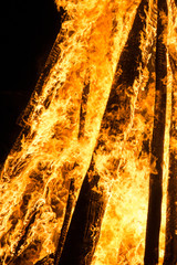 Cone shaped bonfire with big flames and wood