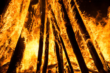 Cone shaped bonfire with big flames and wood