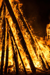 Cone shaped bonfire with big flames and wood