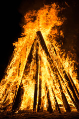 Con shaped bonfire with big flames and wood
