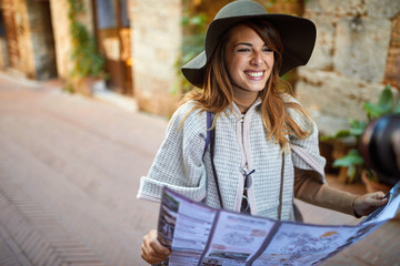 Happy Woman Walking On Street on vacation with sightseeing city with map