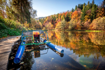 Autumn lake at colorful mountains with vintage pedal boat