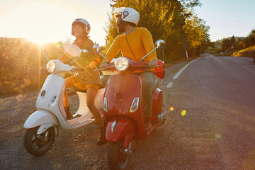 couple laughing and  riding on a scooter in European on vacation. © luckybusiness