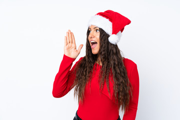 Girl with christmas hat over isolated white background shouting with mouth wide open