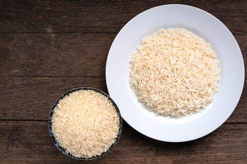 Thai parboiled rice ligth colour. Parboiled rice cooked and un cook on wooden table. Close up shot. Top view.