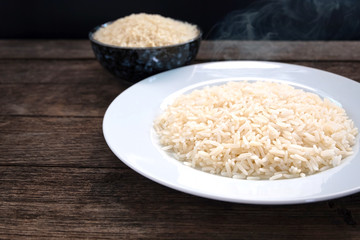 Thai parboiled rice ligth colour. Parboiled rice cooked and un cook on wooden table. Close up shot. 45 degree angle.