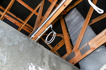 Lighting cables in plastic wiring pipes in a newly built house mounted on roof trusses.