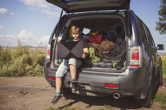 boy using laptop in car