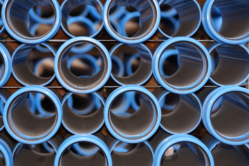 Stapel blauer Abwasserrohre auf einem Lager für ein neues Baugebiet