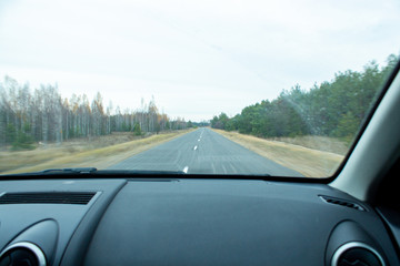 view of the road from the window of a moving car.