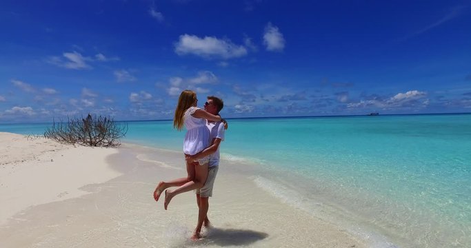 Romantic Engagement Shoot of a Couple on the Exotic White Sand Beach of Hawaii Witnessed by the Bright Sunlight and Blue Sky. Panoramic View