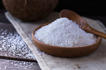 Fresh dried coconut meat chips and coconut on a  wooden table