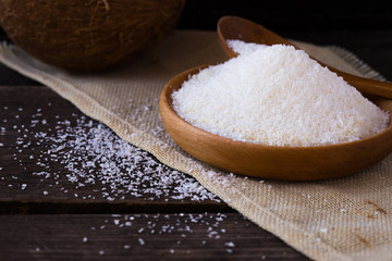 Fresh dried coconut meat chips and coconut on a  wooden table