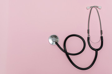 Medical stethoscope on light pink background with copy space for your text. Health care concept.