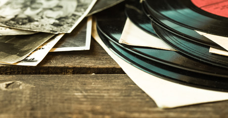 Old vinyl record on the wooden table, selective focus and toned image. family memories