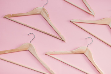 wooden empty clothes hangers on a pink background. concept: pop modern sale