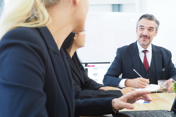 Senior manager talking to his colleagues in the meeting time for new project planning and setting up competitive strategy Team building business discussion and sharing idea for successful work concept