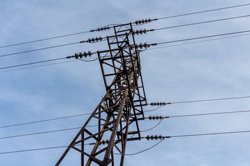 Rusty power line is on the blue sky background
