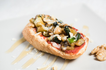 Spanish vegetarian tapas baked vegetables on bread with sauce. Eggplant, chickpeas