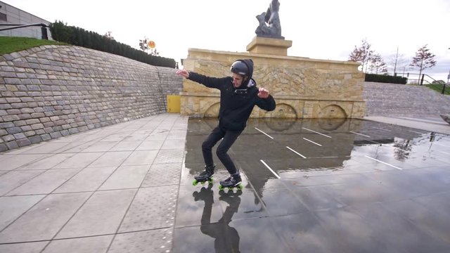 Skater performs beautiful slide on water in slow motion