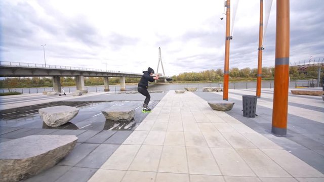 Man jumps on skates on stone and from it Extreme promenade skating in slow motion