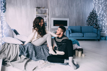 A guy with a girl is celebrating Christmas. A loving couple enjoys each other on New Year's Eve in a cozy home environment. New Year's love story.