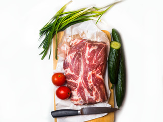 Raw pork meat isolated on white background, with cucumber, tomatoes, green onion