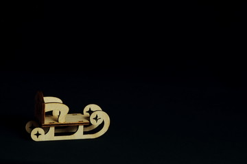 Stylized original wooden sled for decoupage on black background. Concept Christmas, holiday, New Year, congratulatory background. Minimal style with copy space.