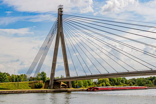 View of the cable ties of the cable-stayed Lanaye Bridge that crosses the Albert Canal, a wonderful summer day with a blue sky and white clouds in Belgium