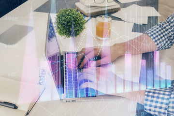 Multi exposure of graph with man typing on computer in office on background. Concept of hard work....