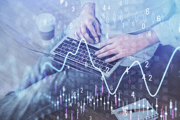 Forex graph with businessman working on computer in office on background. Concept of analysis. Double exposure.