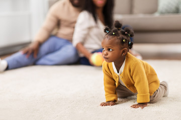 childhood and people concept - african american baby crawling on floor at home