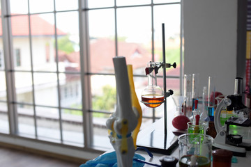 glass test tubes and flasks with colorful liquid on blue background with molecular structure