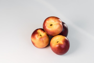 Ripe red nectarines, peaches, apples on a white table. Tasty bright fruits. Isolated object.