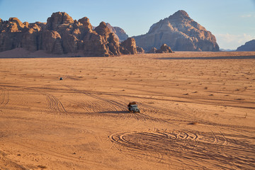 Truck driving in Wadi Rum desert at sunset, Jordan