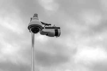 Security camera against a cloudy, stormy sky.
