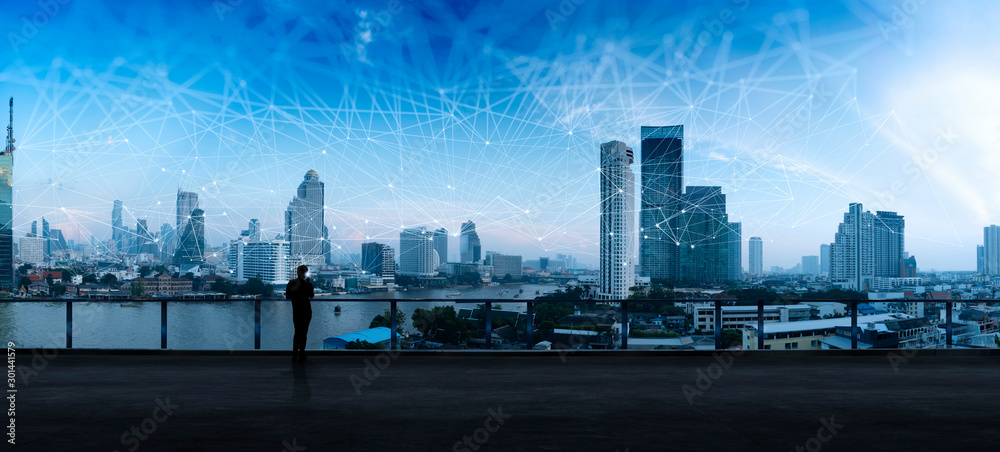Leinwandbilder businessman standing using smart phone in modern space watching city night view.business wireless ne