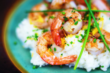 Shrimp and grits on a turquoise blue plate. Close view. 